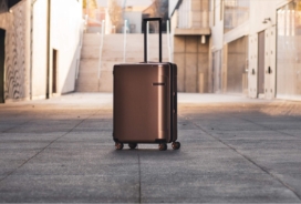 A single suitcase sitting on concrete area.