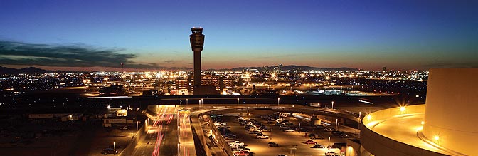 Overview shot of PHX Sky Harbor International Airport and its air traffic control tower at night.