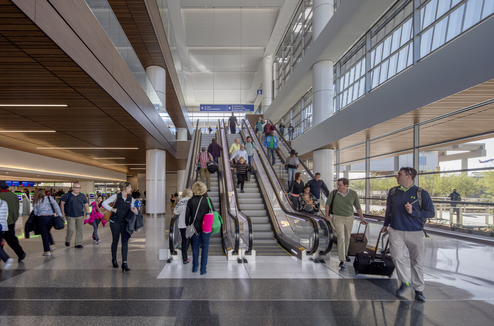 Escalators and stairs with airport passengers