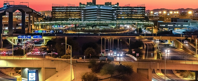 Public transportation in front of the Phoenix downtown skyline at night.